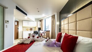A modern hotel room with a large bed, a red runner, and a view of the city. - VR Queen Street - Hotel & Suites (Auckland)