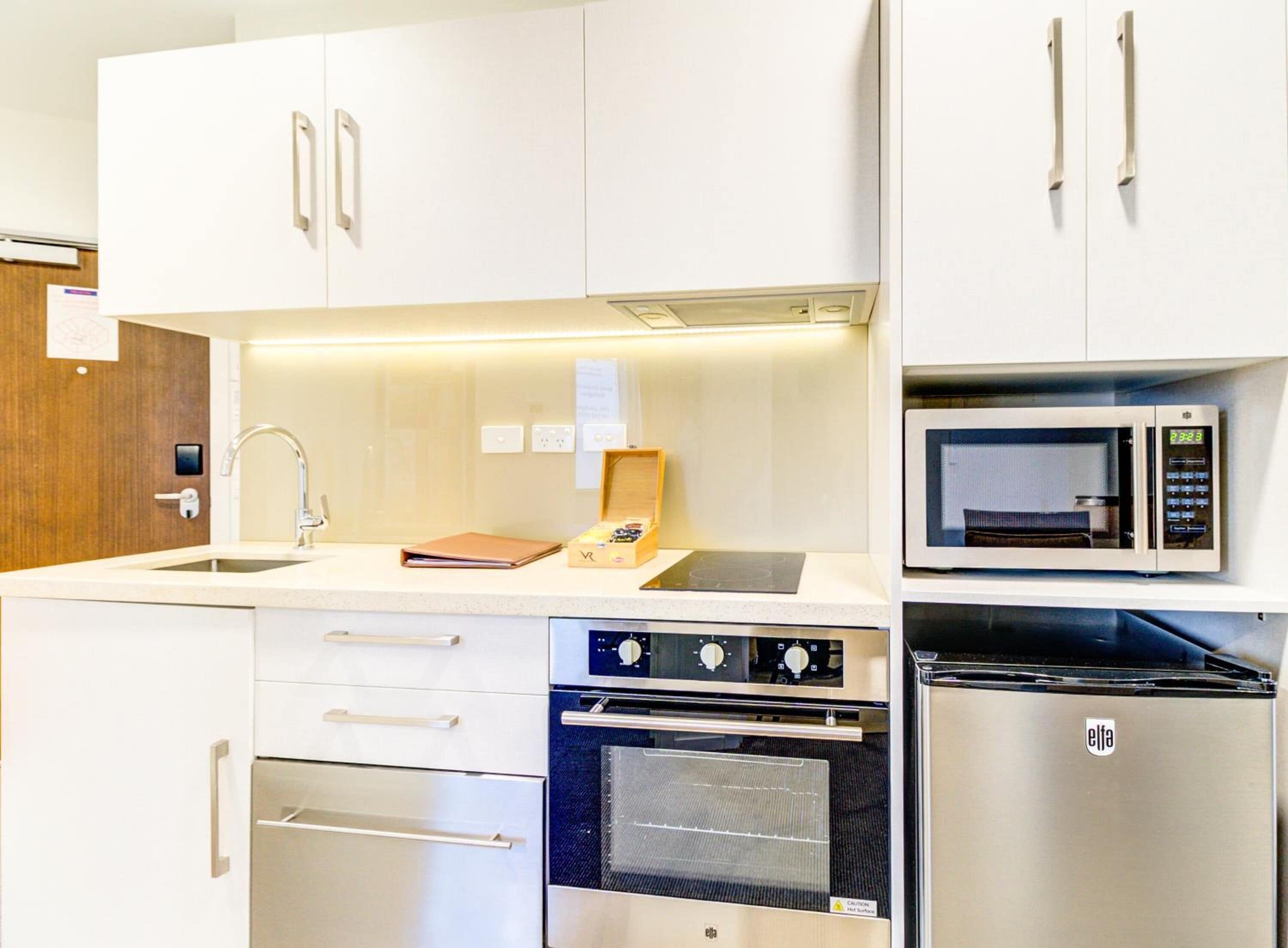 A modern kitchen with stainless steel appliances, including a microwave, oven, and stove.