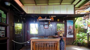 Un espace d’accueil avec des meubles en bois, un comptoir de réception et une enseigne indiquant « RÉCEPTION ».