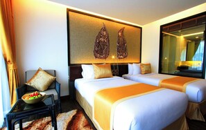Una habitación de hotel con dos camas, una mesita de noche, un frutero y una gran obra de arte en la pared.