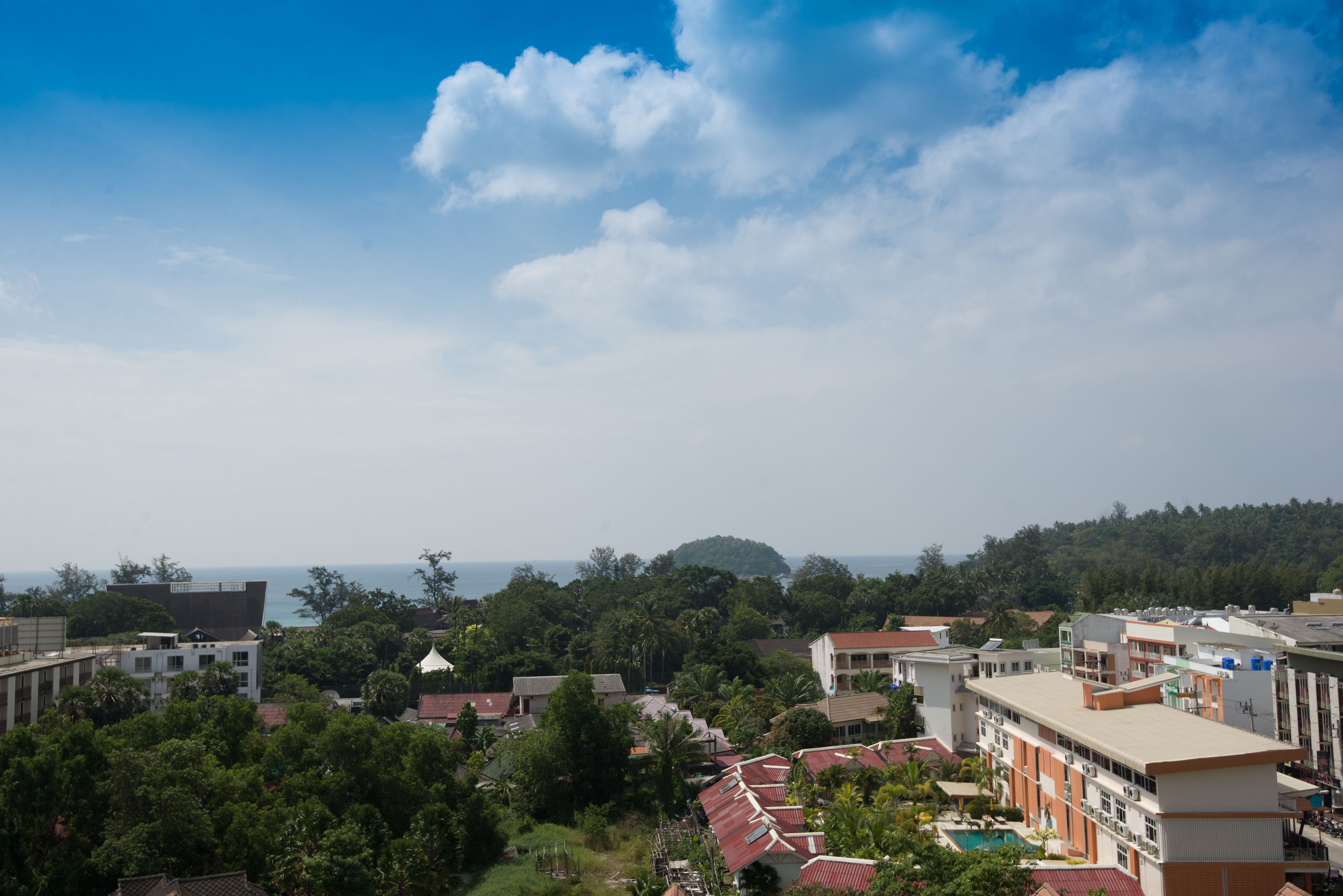 A residential area with buildings, trees, and a clear sky.