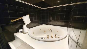 A modern bathroom with a freestanding bathtub, a towel rack, and a toilet.