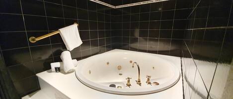Un baño moderno con una bañera independiente, un perchero y un inodoro.