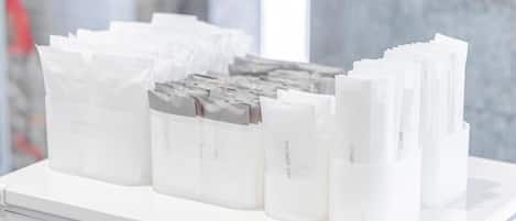 A white storage unit with multiple compartments, some labeled with "Shower Cap" and "Come."