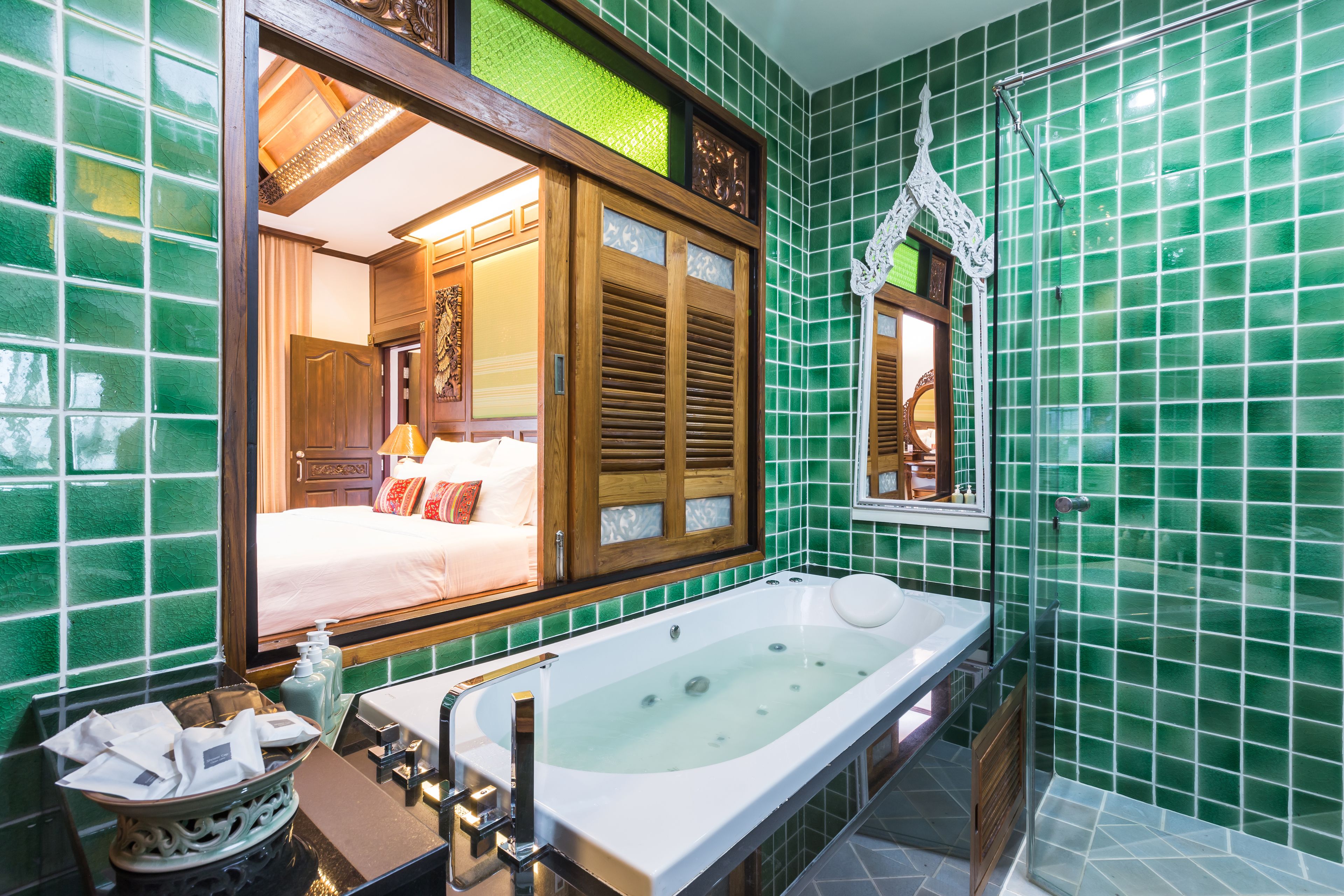 A bathroom with a large bathtub, a sink, and a mirror.