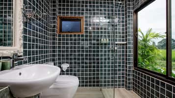 A bathroom with a large window, a sink, a toilet, and a shower.