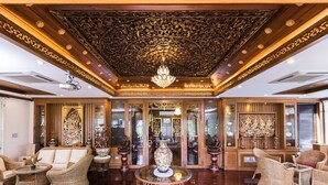Eine luxuriöse Lobby mit aufwendiger Decke, Korbmöbeln und traditionellen Kunstwerken.