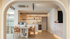 Una cocina moderna con una isla, sillas de madera y una mesa de comedor.