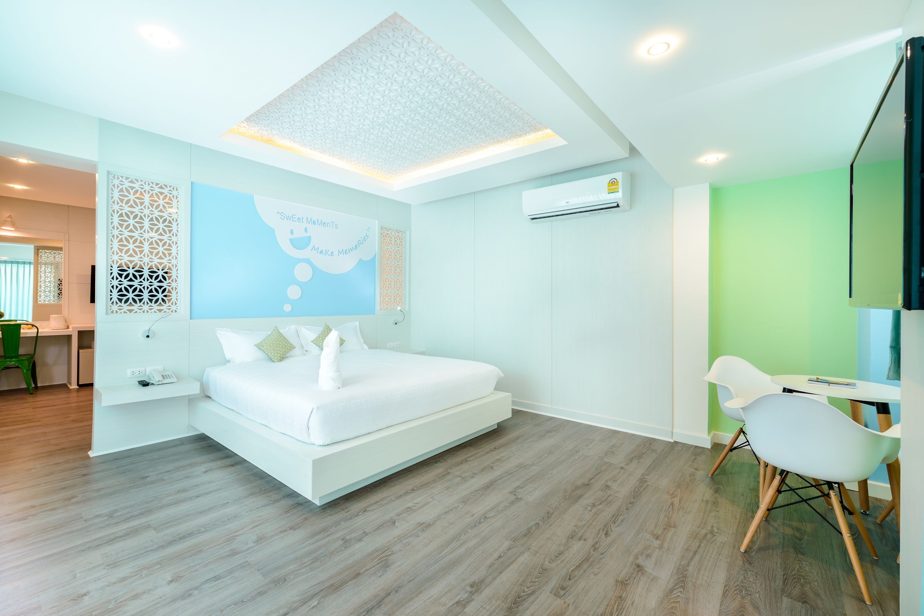 A modern hotel room with a bed, a desk, and a chair.