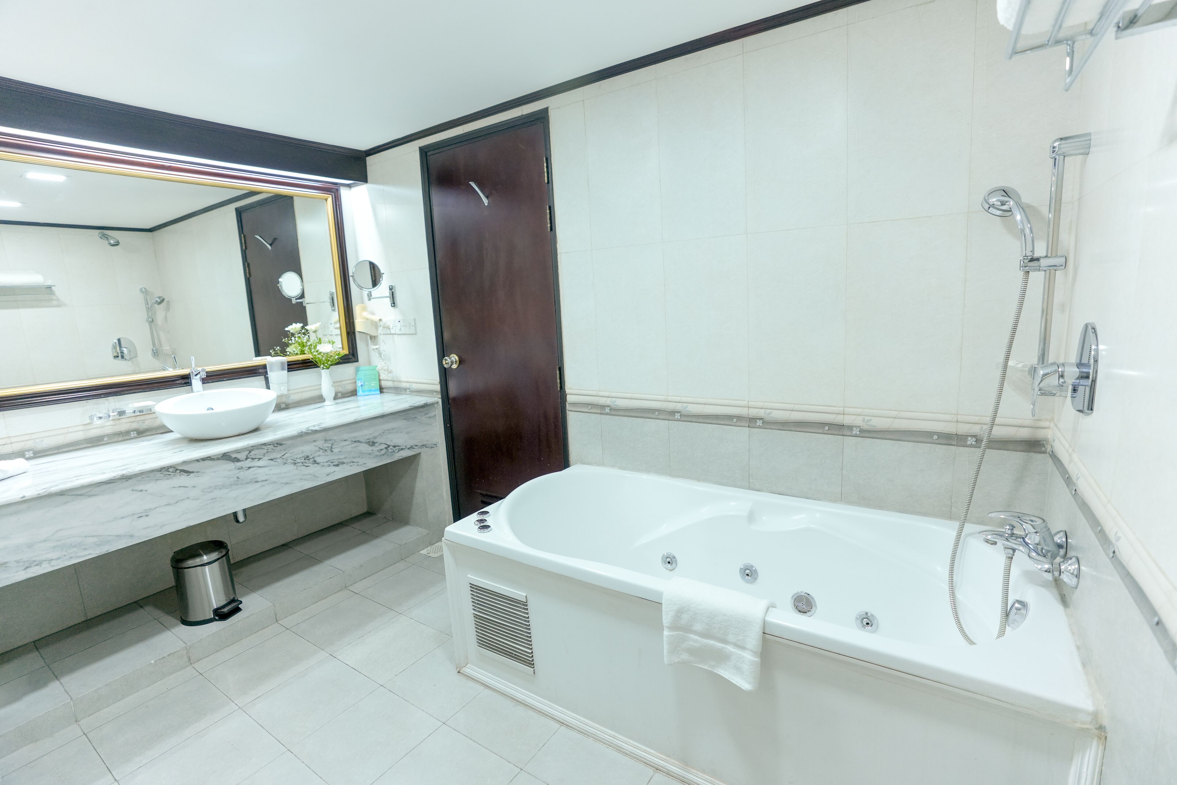 A modern bathroom with a large bathtub, a sink, and a shower.