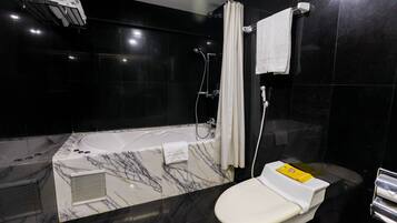 Un baño moderno con bañera, inodoro y ducha.