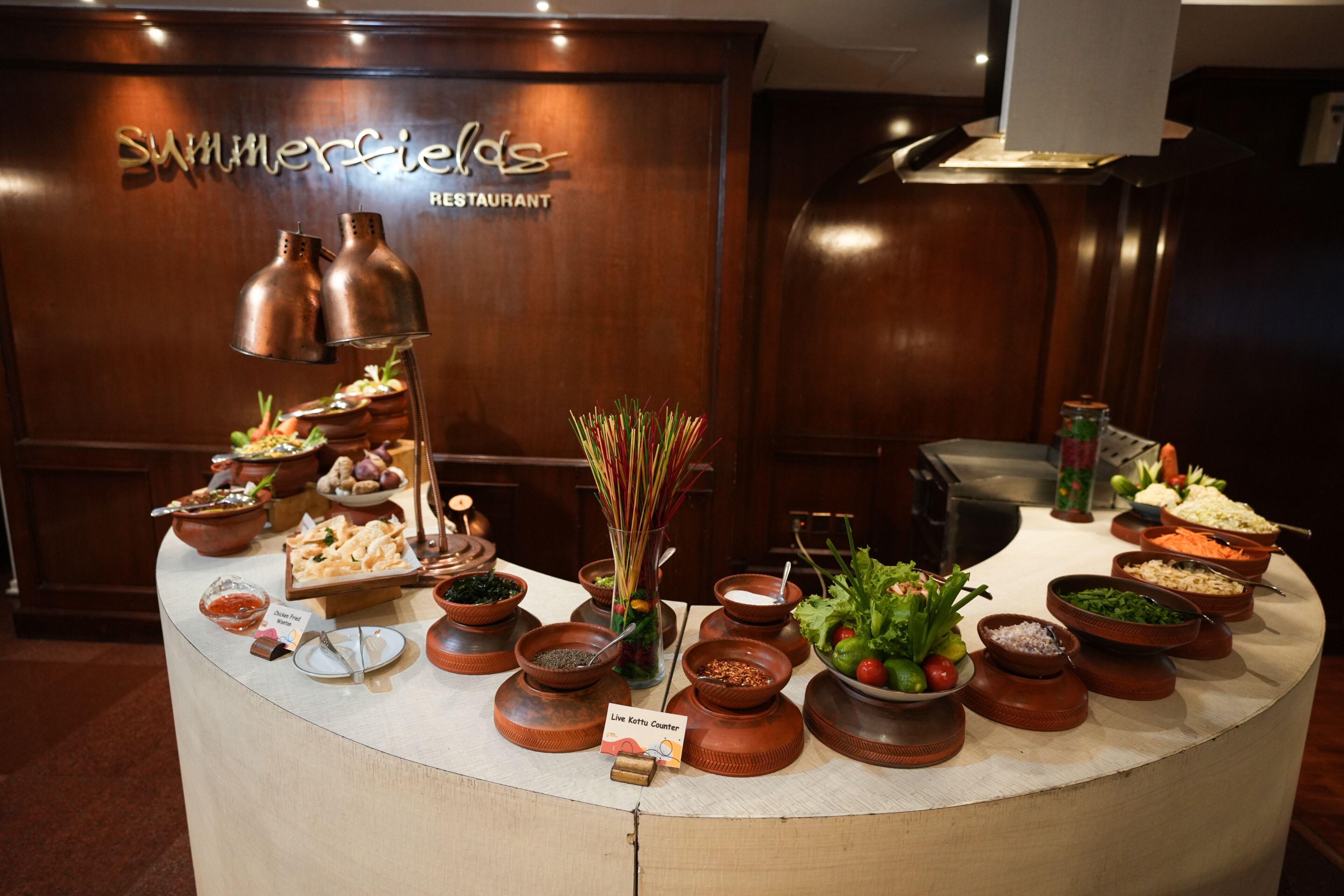 A buffet setup with various dishes and a live katsu counter at a restaurant.