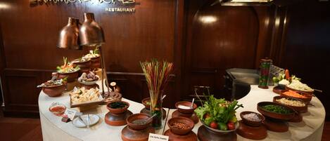 A buffet setup with various dishes and a live katsu counter at a restaurant.