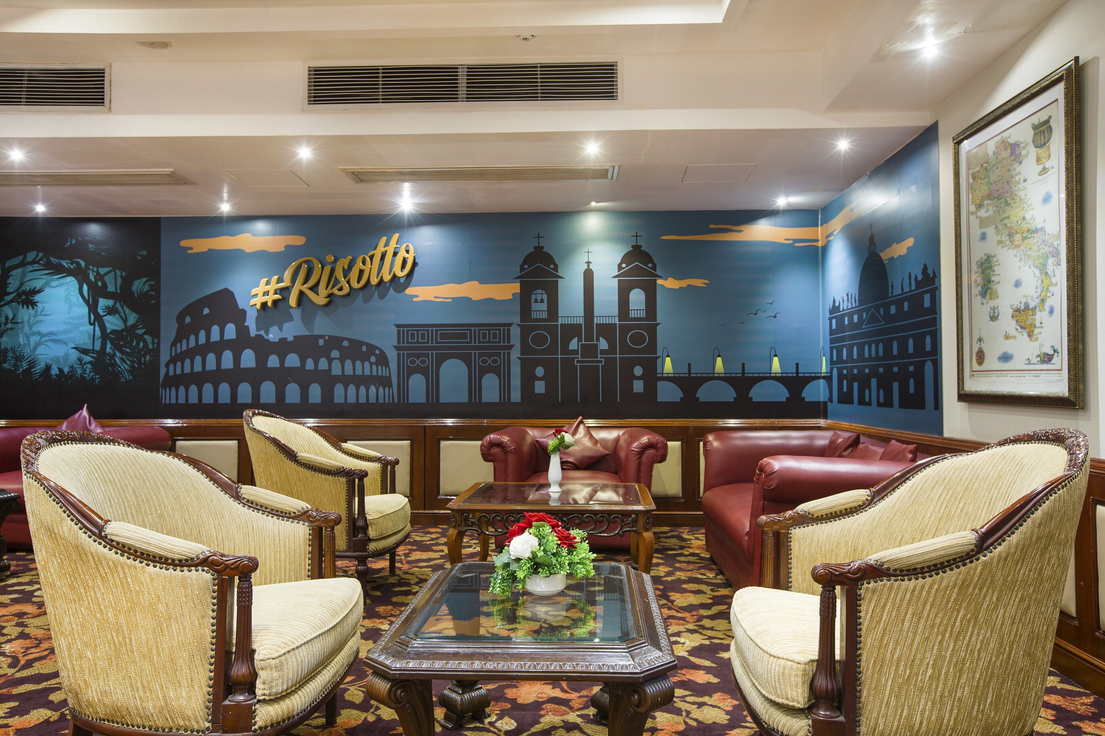 A lobby with a mural of Rome's landmarks, leather sofas, and classic armchairs.