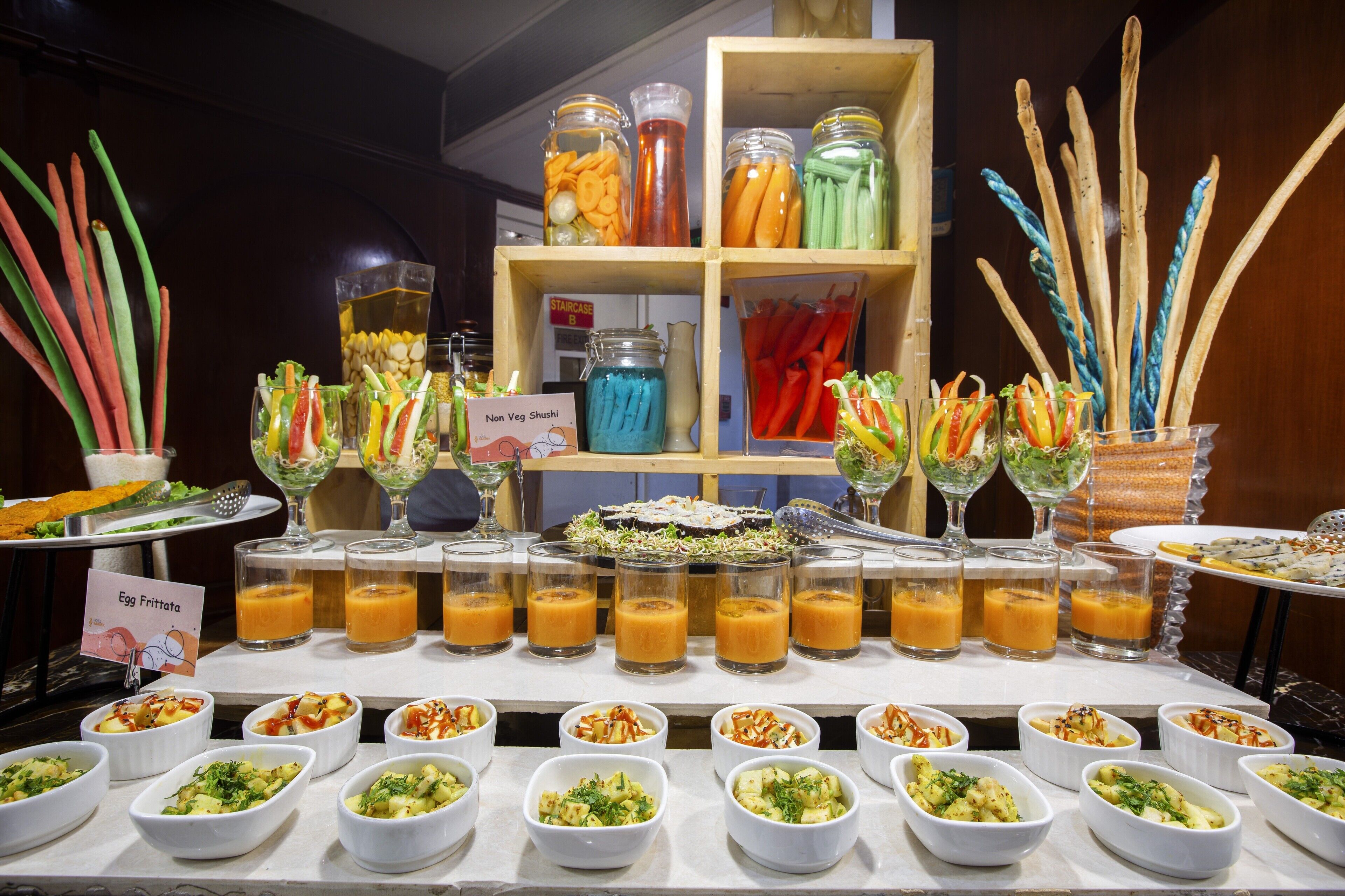 A buffet with various dishes and drinks, including a sign for 'Non Veg Shushi'.