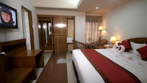 A hotel room with a bed, a desk, a chair, a TV, and a bathroom visible through an open door. - Hotel Victory (Dhaka)