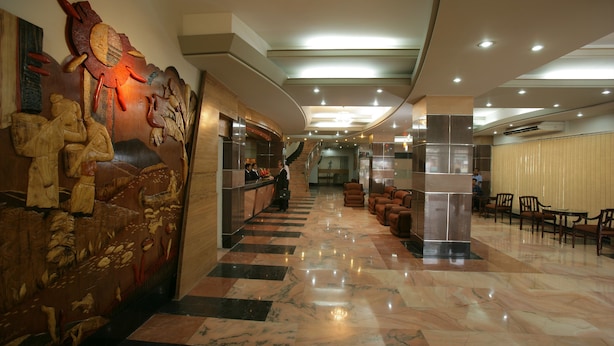 A lobby with a reception desk, a staircase, and seating areas. - Hotel Victory (Dhaka)