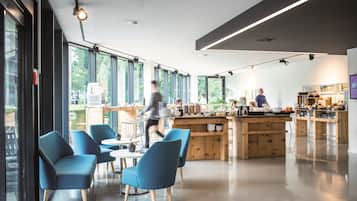 A modern cafe with blue chairs, a wooden counter, and large windows.