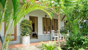 Uma casa pequena com jardim, porta e janela.