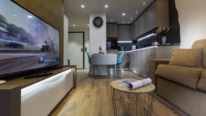 Una sala de estar moderna con televisor, sofá y zona de comedor.
