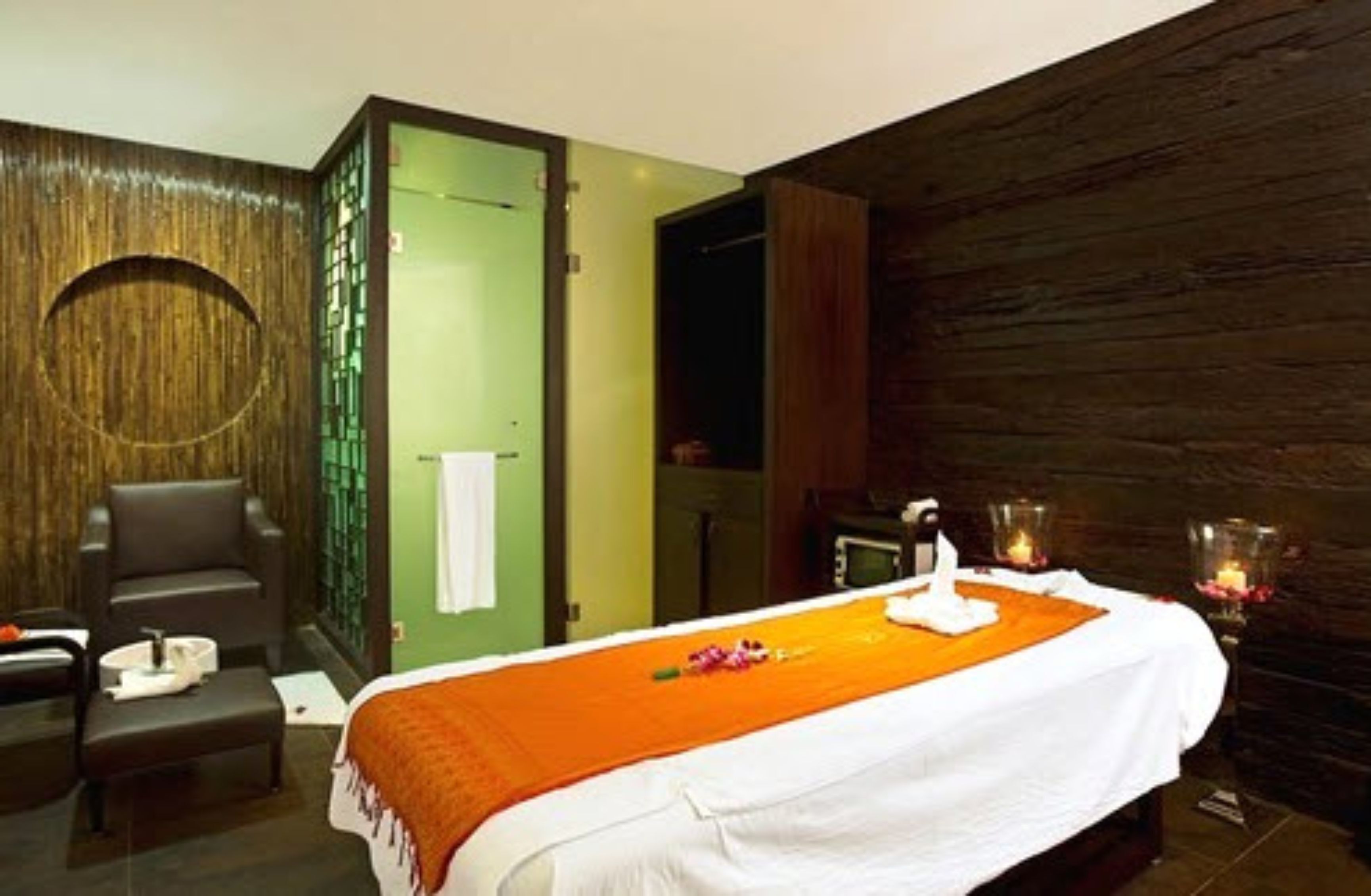 Un cuarto de spa con una cama, una camilla de masaje y un área de descanso.