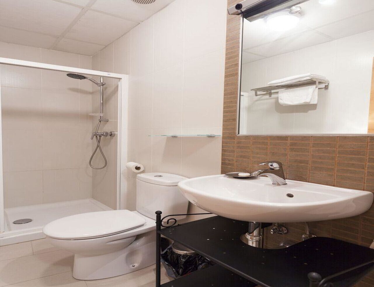 A bathroom with a shower, toilet, and sink.
