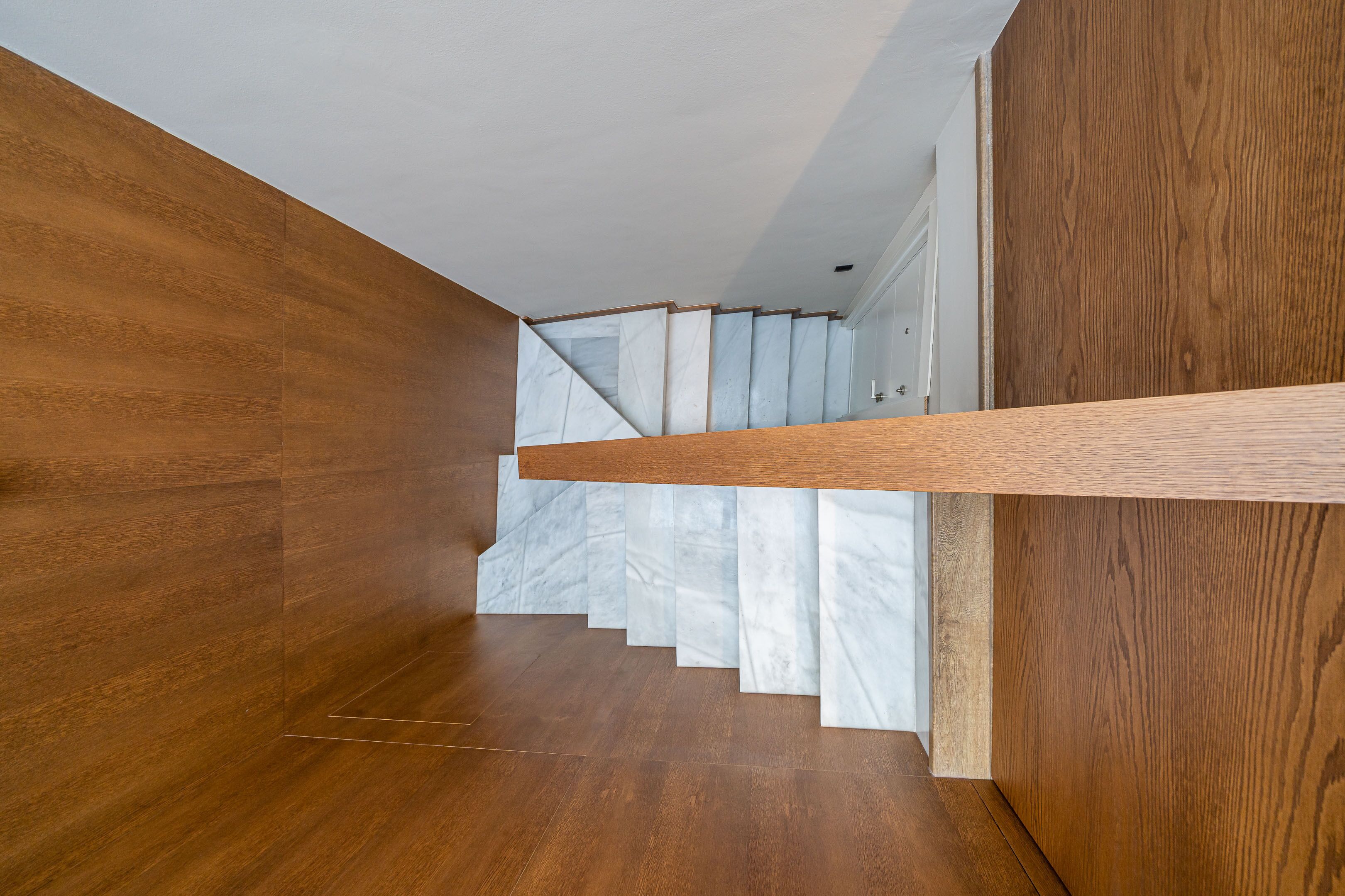 Una escalera moderna con escalones y barandilla de madera.