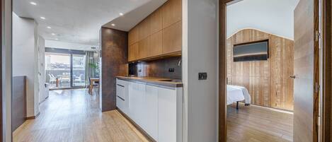 A modern kitchen with wooden cabinets, a built-in oven, and a large window.