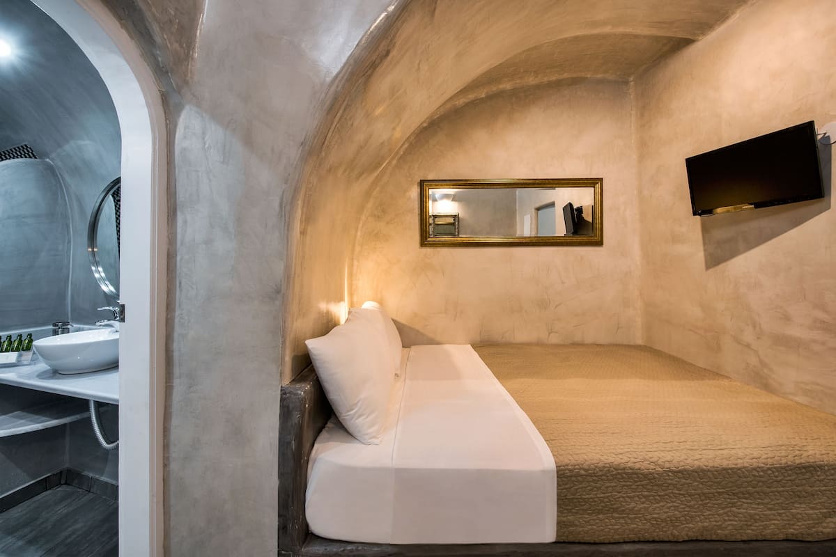 A modern bathroom with a white sink, mirror, and a white sofa bed.
