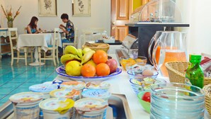 Un buffet de petit-déjeuner proposant une variété d’aliments et un espace repas avec des tables et des chaises.