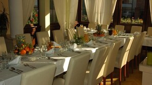 A dining area with tables set for a meal, featuring white tablecloths, chairs, and a variety of table settings including plates, glasses, and a fruit bowl. - U Pana Cogito (Kraków)