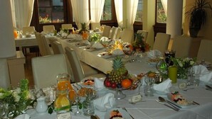 A dining area with tables set for a meal, featuring fruit and beverages. - U Pana Cogito (Kraków)