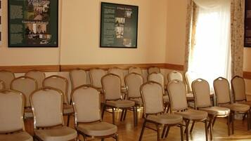 A conference room with rows of chairs, a chandelier, and educational posters on the walls.
