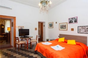 Een hotelkamer met een bed, een televisie, een bureau en stoelen.
