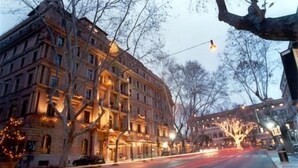 Un edificio de varios pisos con un estilo arquitectónico clásico, que cuenta con amplias ventanas y una entrada destacada.