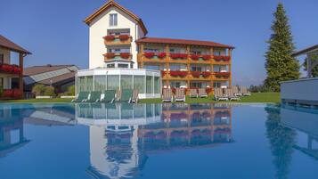Una piscina cubierta, una piscina al aire libre, sombrillas, tumbonas
