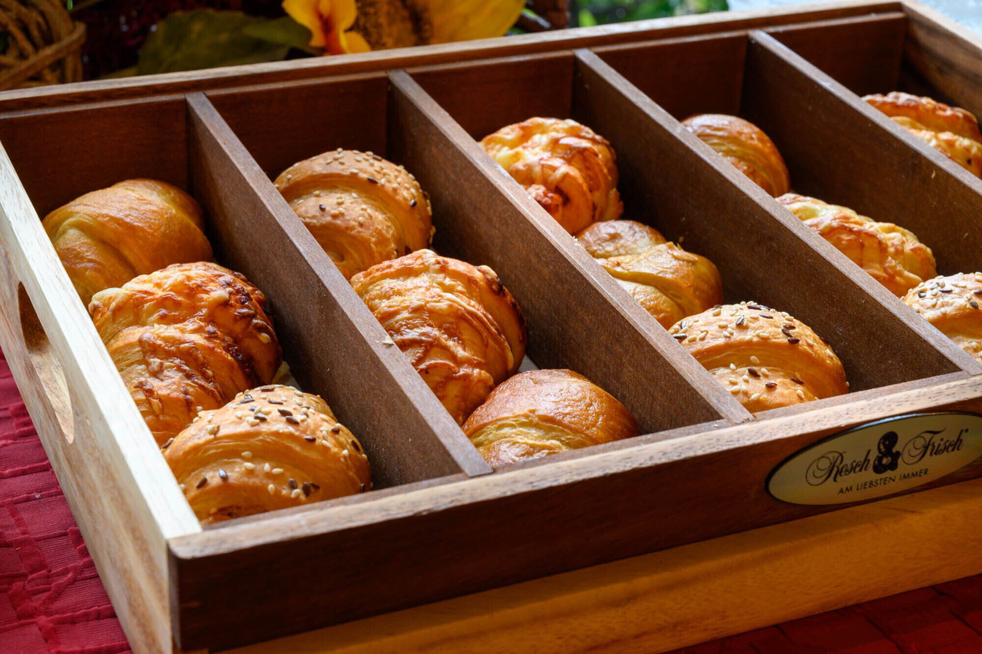 Uma caixa de madeira com diversos tipos de pão.