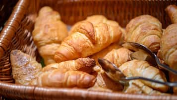Un panier en osier rempli de croissants de différentes sortes.