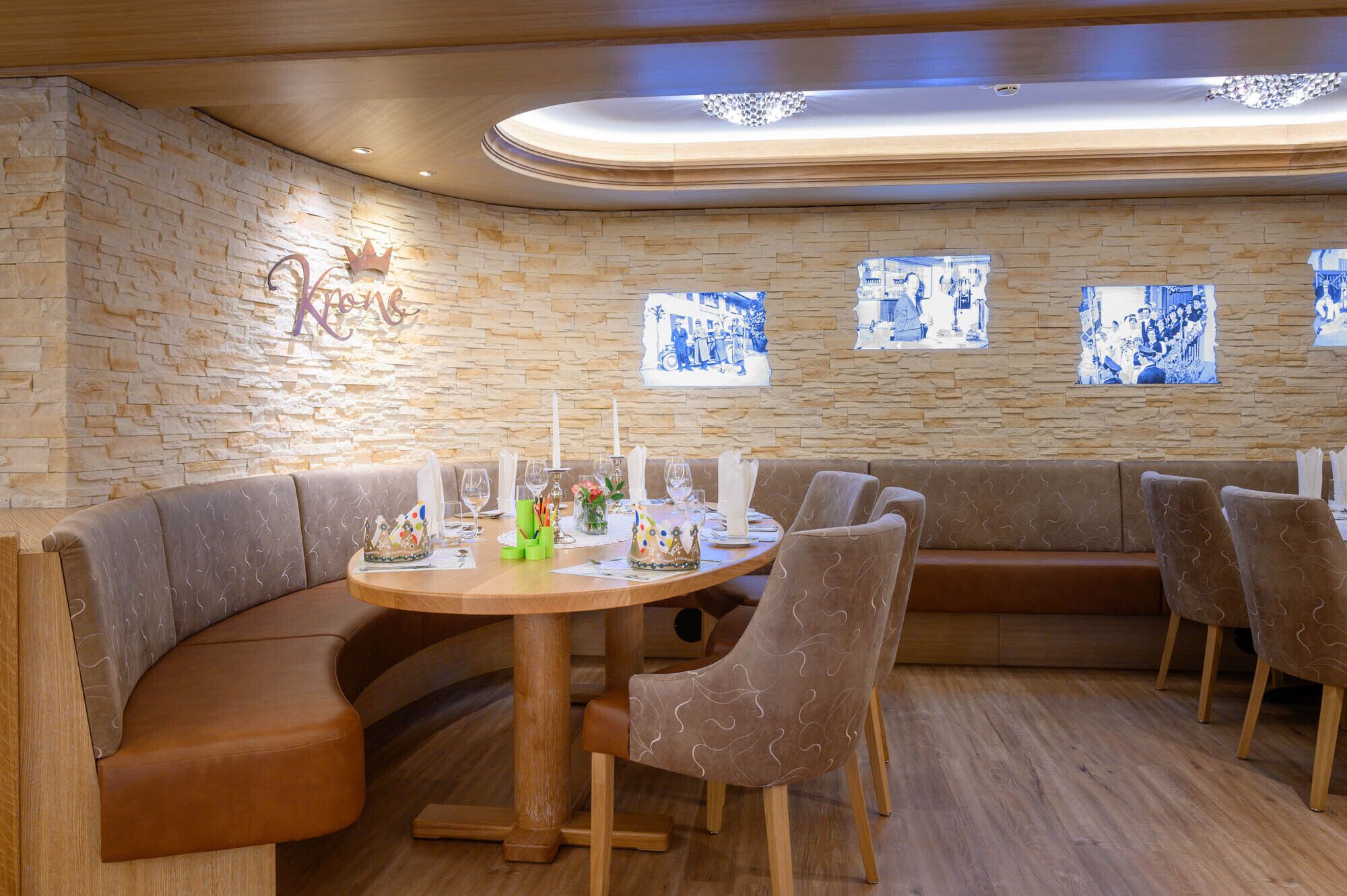 Un restaurante con pared de piedra, una mesa redonda con sillas y un sofá.
