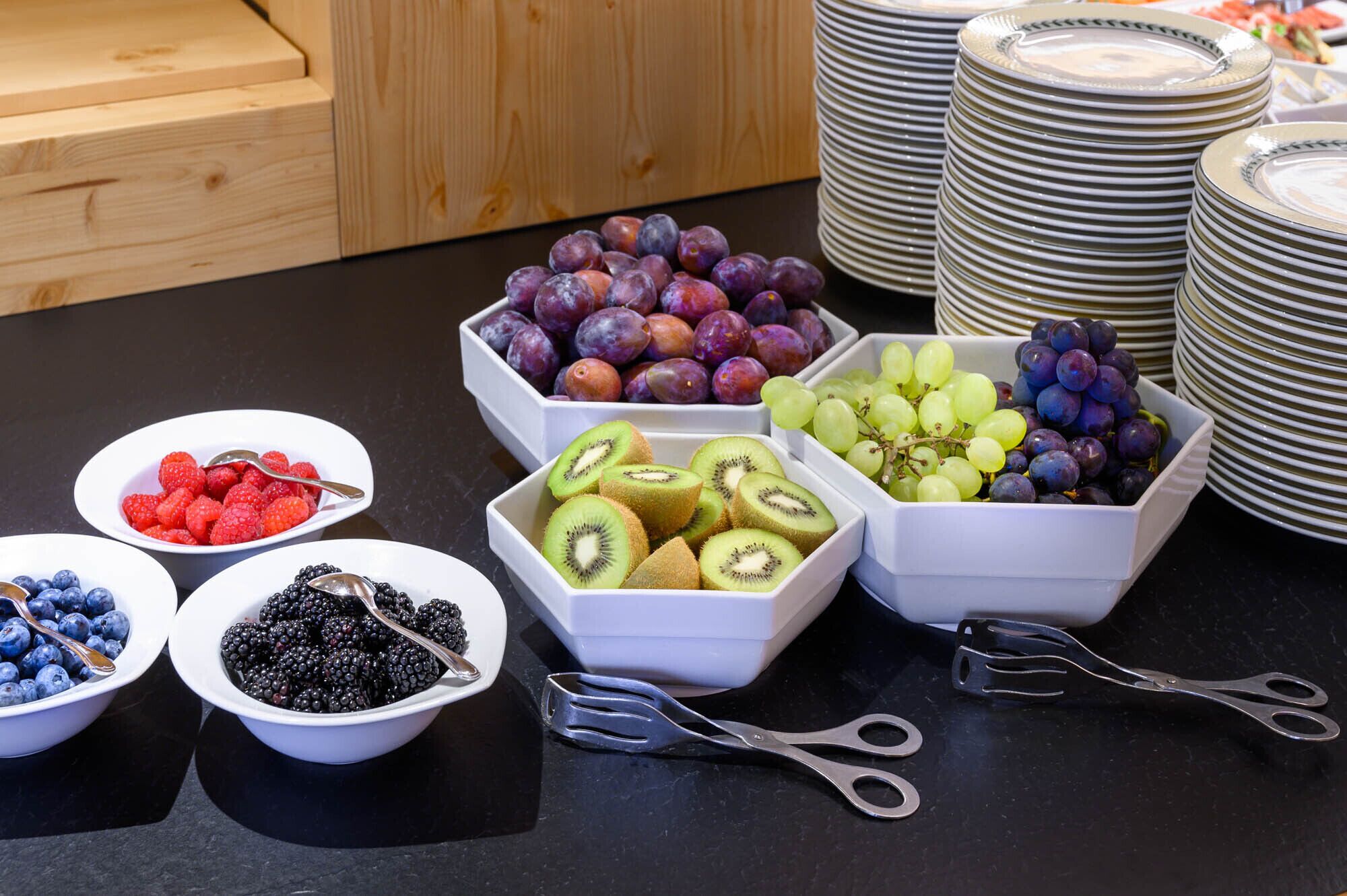Ein Buffet mit verschiedenen Früchten und Schalen voll Beeren.