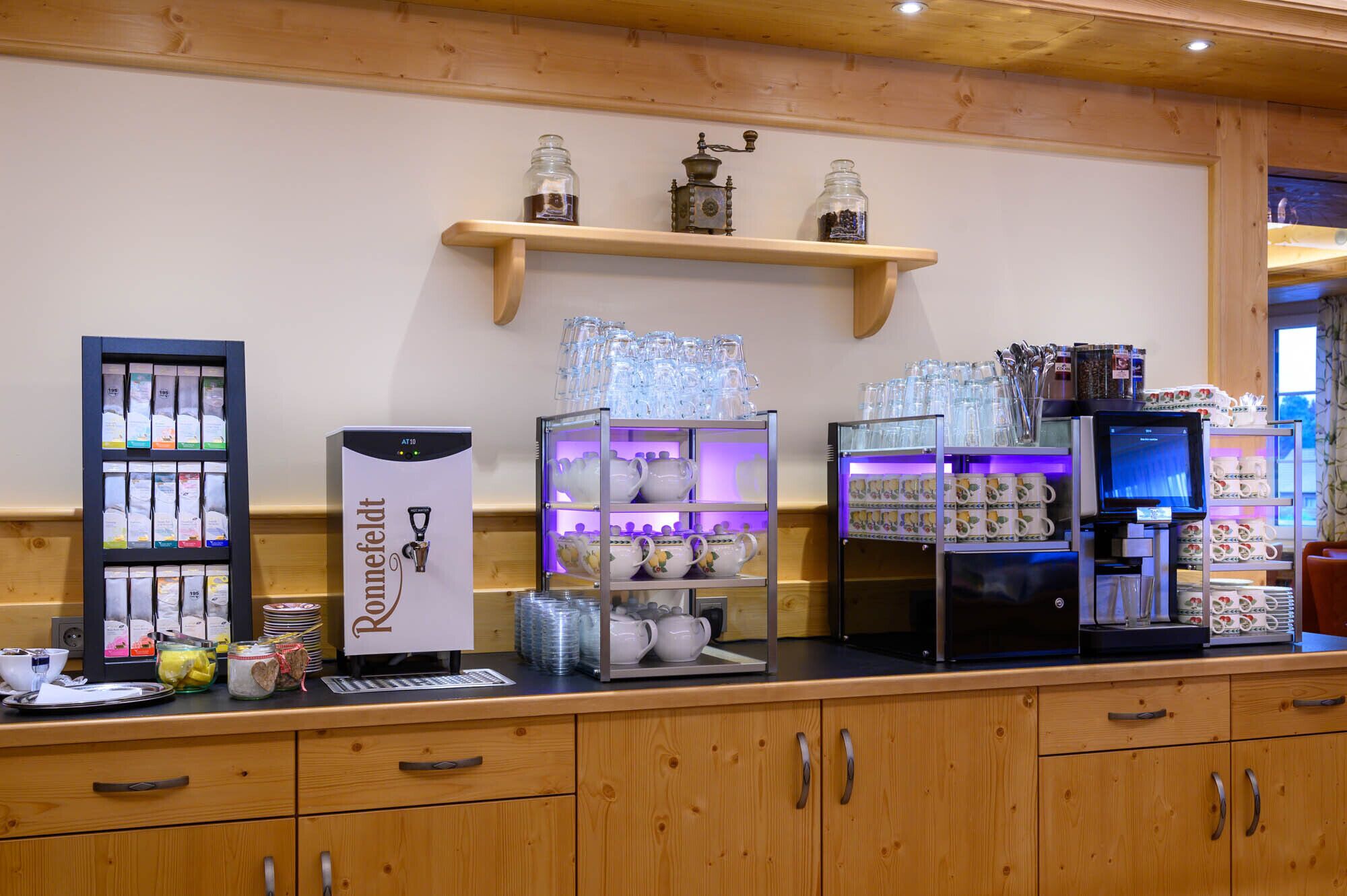 Eine Kaffeestation mit Kaffeemaschine, Teekannen sowie verschiedenen Tassen und Gläsern.