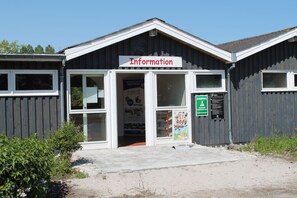 Un bâtiment avec une enseigne indiquant « Informations » et un panneau vert indiquant un parking.