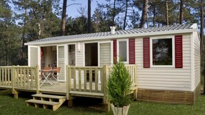 A mobile home with a deck, a small patio, and a potted plant. - Marielyst Feriepark & Camping (Vaeggerlose)
