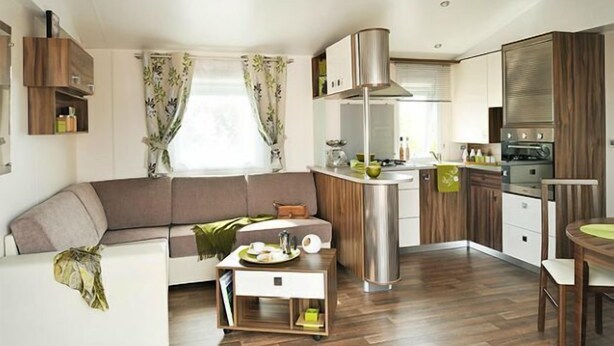 A compact living space with a sofa, a small side table, a kitchenette, and a dining area. - Marielyst Feriepark & Camping (Vaeggerlose)