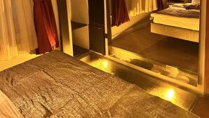 Un dormitorio con una litera, un espejo y una mesita de noche.