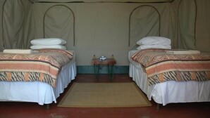 Una carpa con dos camas, cada una con ropa de cama y almohadas estampadas.