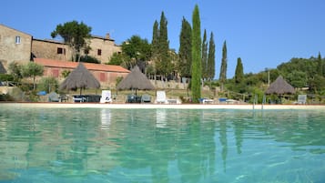 Una piscina al aire libre de temporada, sombrillas