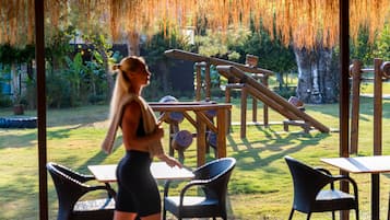 Guests can dine al fresco amidst lush greenery and a play area for kids.