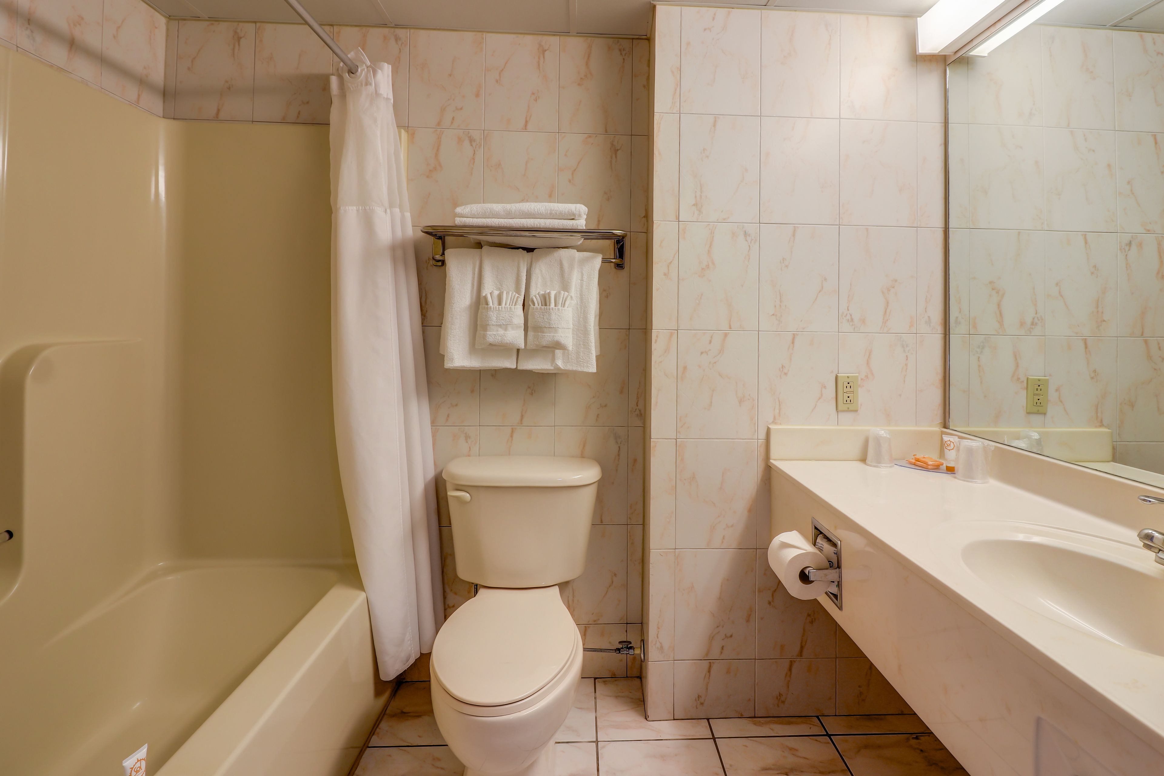 A bathroom with a bathtub, toilet, and sink.