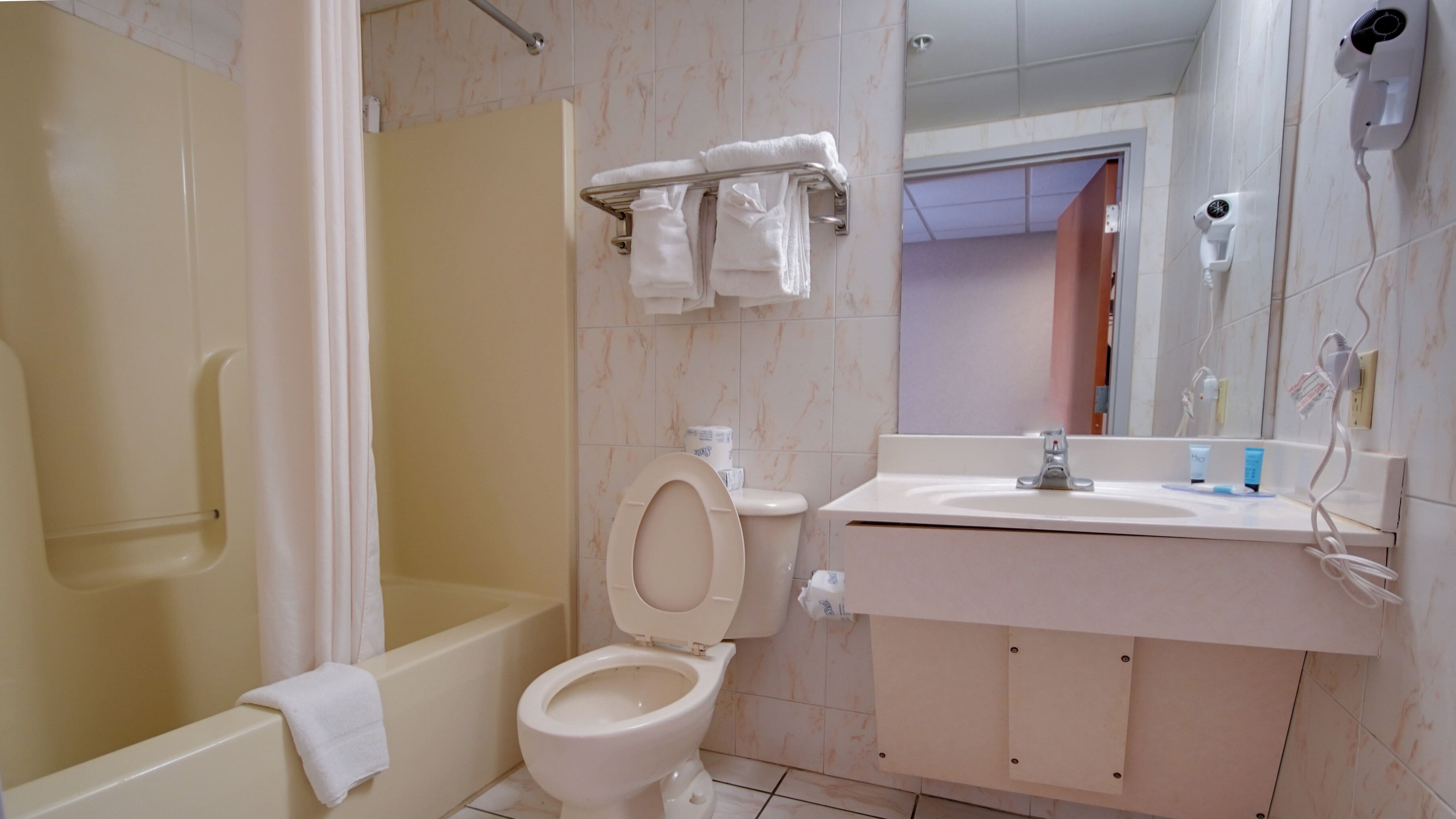 A bathroom with a bathtub, toilet, and sink.